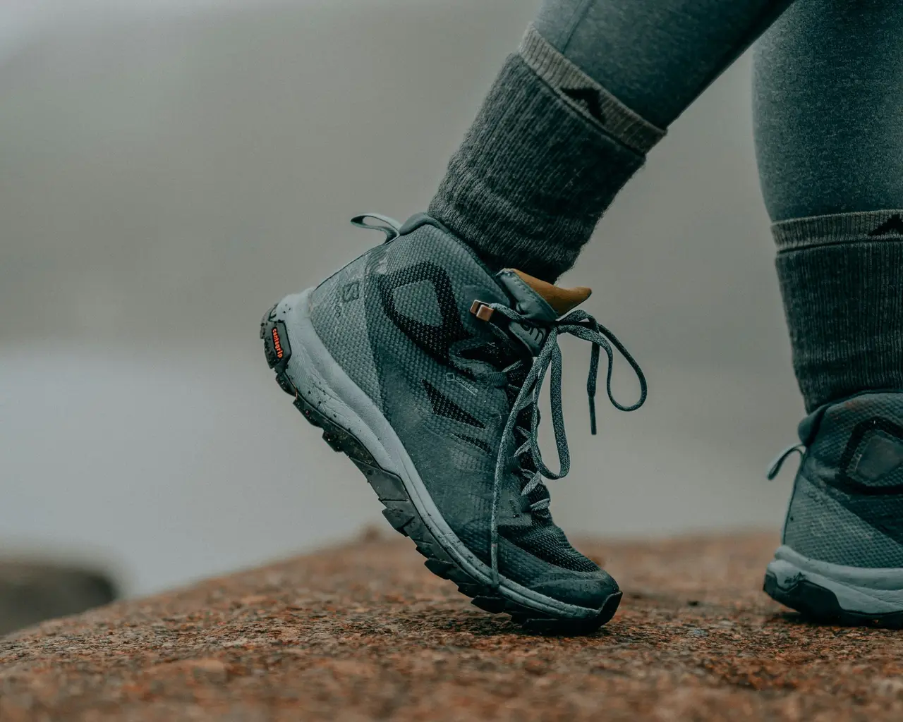 A hiker's boots mid-step on a mountain trail
