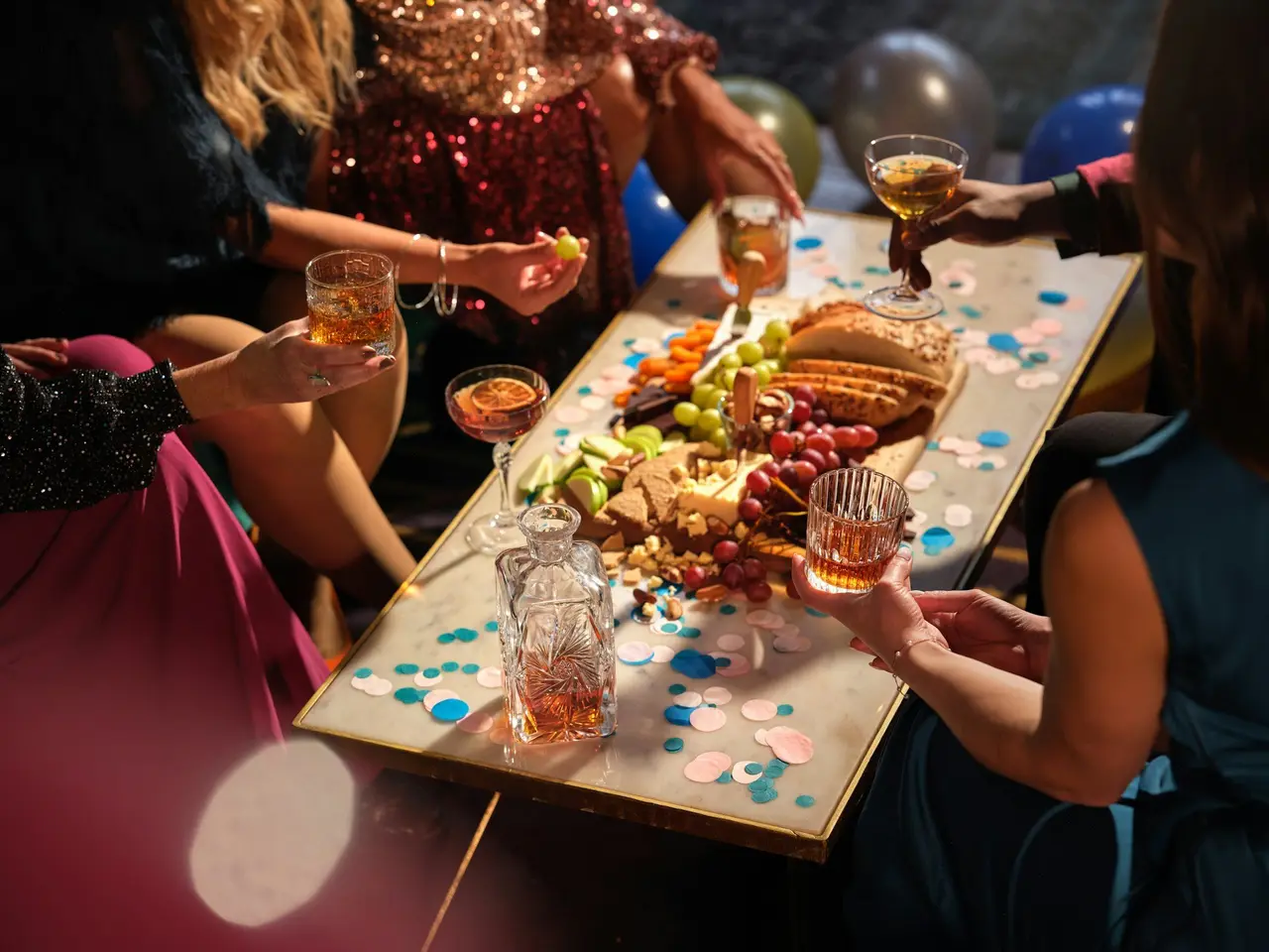 Friends reaching across a table for a shared platter