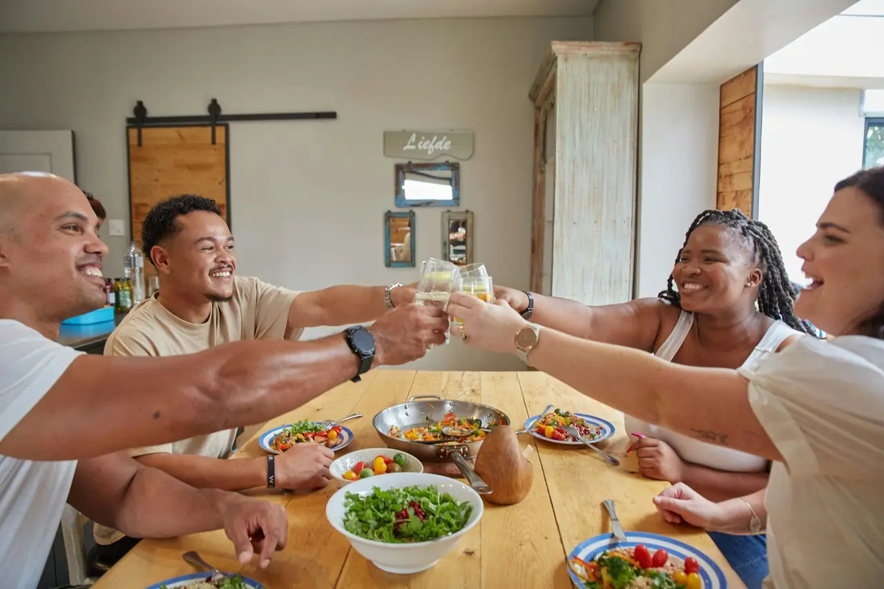 Friends raising glasses around a dinner table