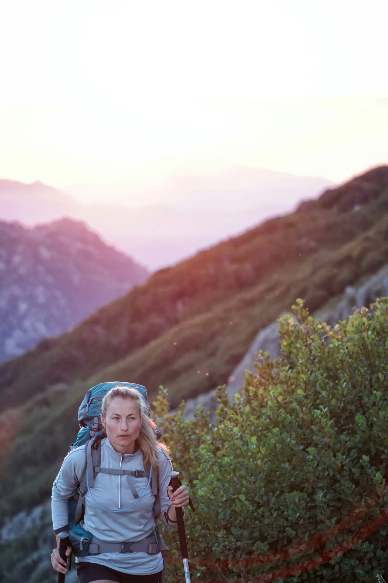 A hiker smiling on a mountain trail