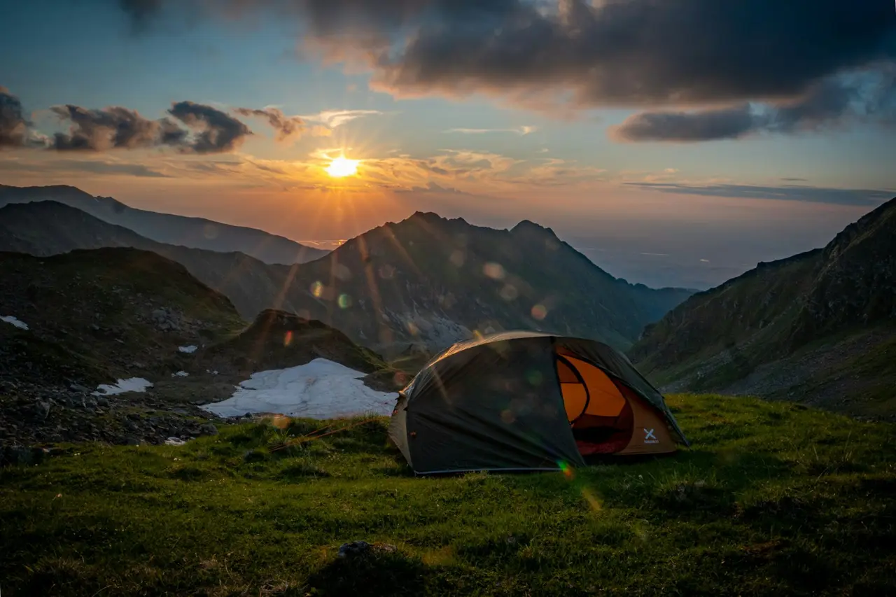 A tent pitched on a mountain ridge at sunset